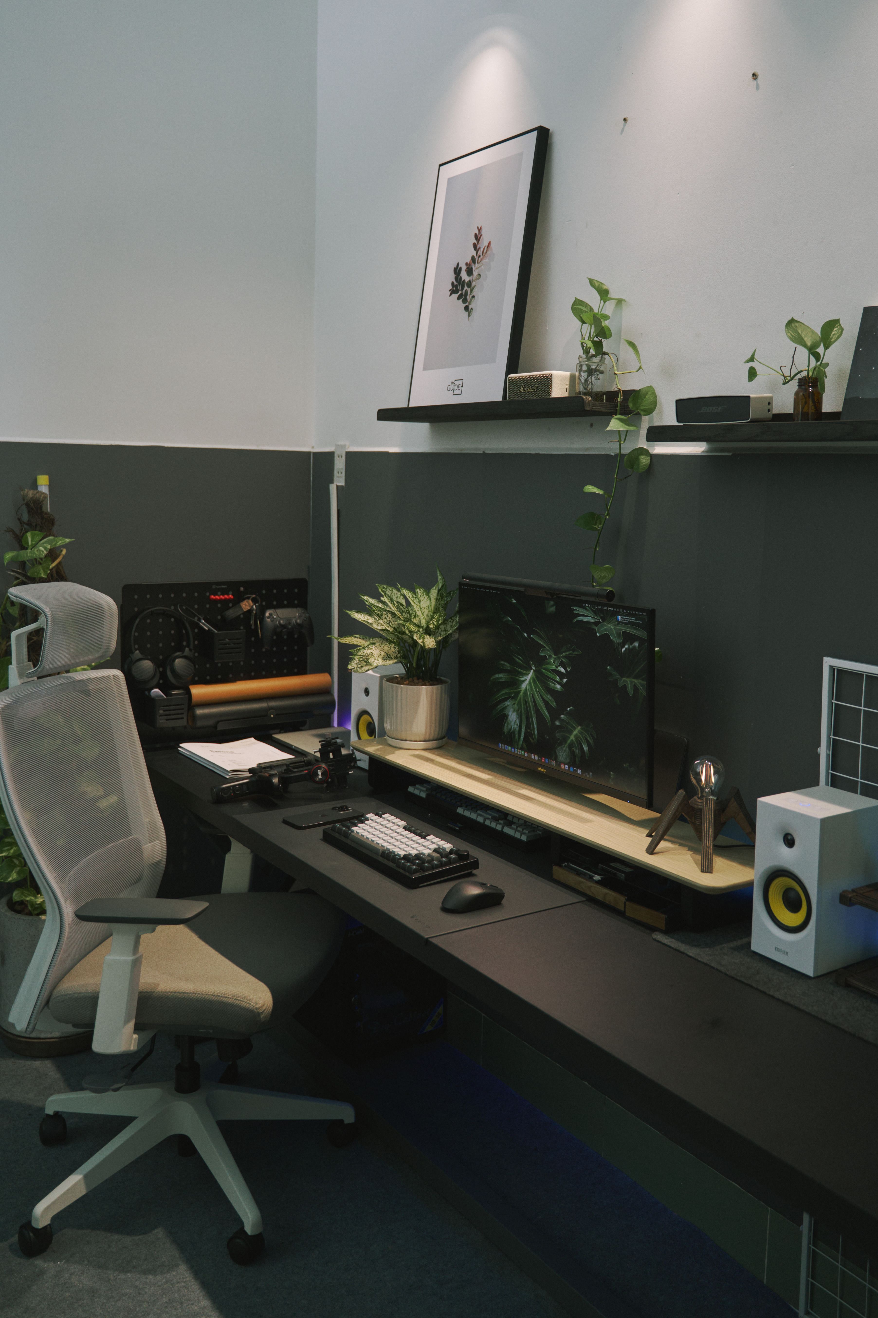 A stylish home office setup featuring plants, a monitor, and a modern desk in Can Tho, Vietnam.