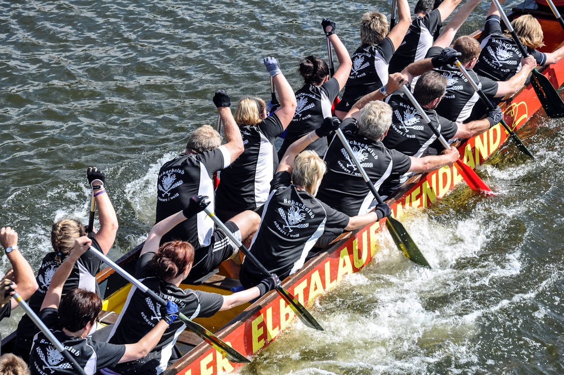 Group of People Rowing in a Race Boat · Free Stock Photo