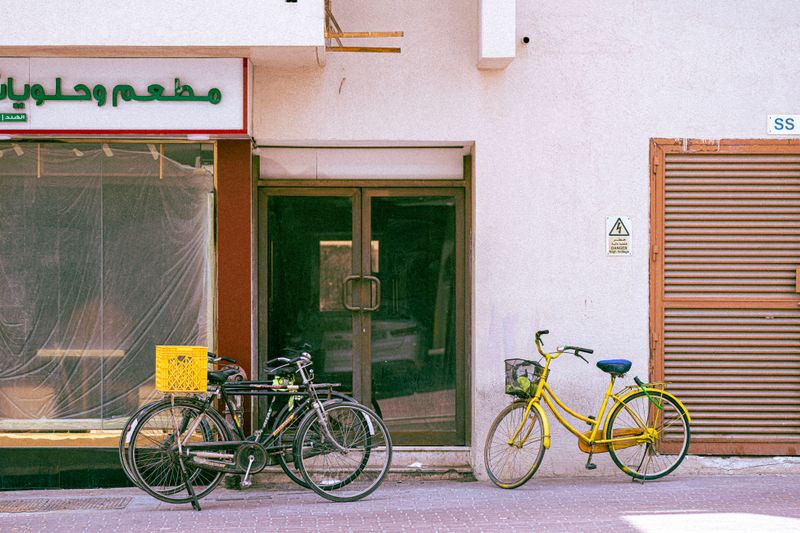 Vibrant bicycles parked outside a Dubai storefront on a sunny day.