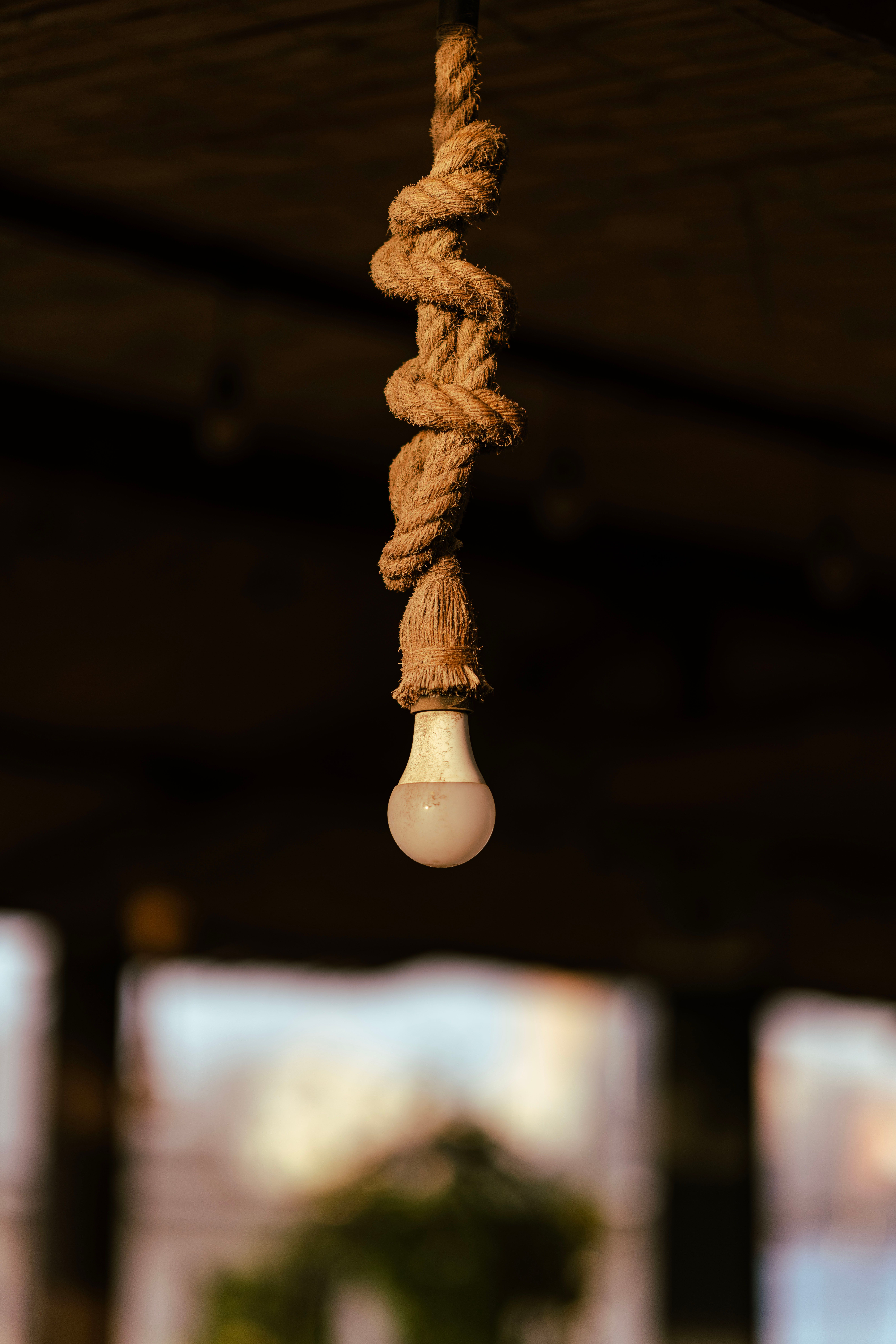 Close-up of a vintage-style light bulb wrapped with rope in a Dubai café setting.