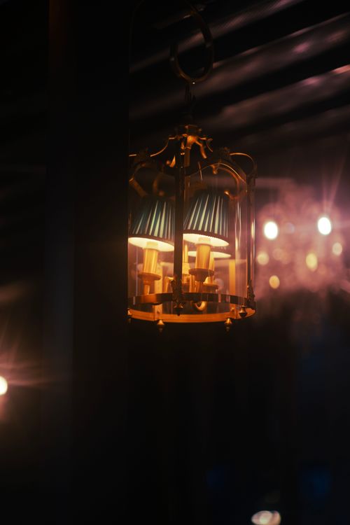 Free A vintage chandelier casting warm light in a dimly lit Dubai interior, creating a cozy ambiance. Stock Photo