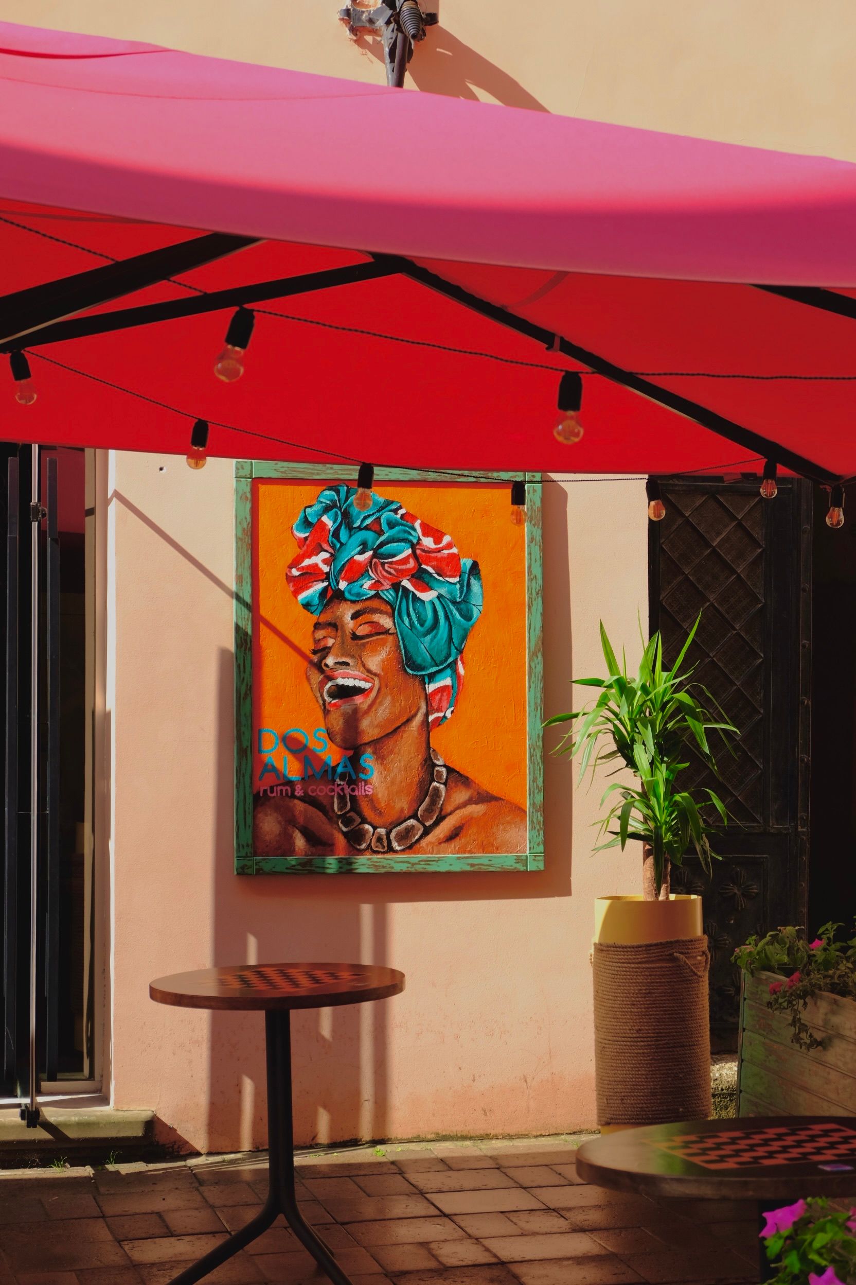Vibrant African artwork displayed under a red awning in an urban Lviv setting with outdoor seating.