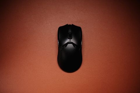 Black wireless mouse on an orange background