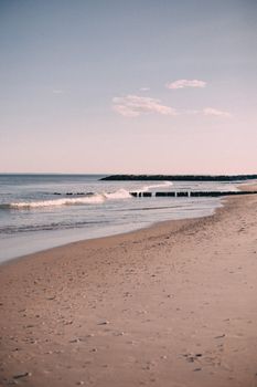 Tranquil sandy beach with gentle waves and clear sky in New York City.