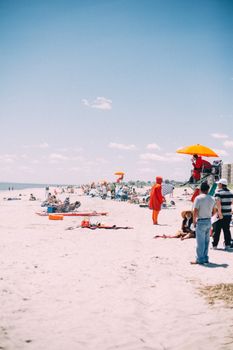 Lively beach day with people enjoying the sun and sand in New York City.