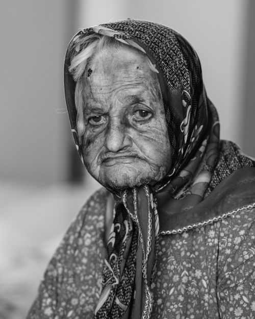 Free Intimate black and white portrait of a senior woman with a headscarf, deeply expressive face and wrinkles. Stock Photo