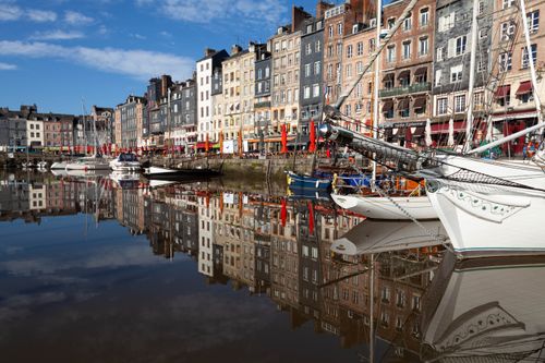 Free Charming view of Honfleur's colorful buildings reflecting on the water, showcasing moored boats. Stock Photo