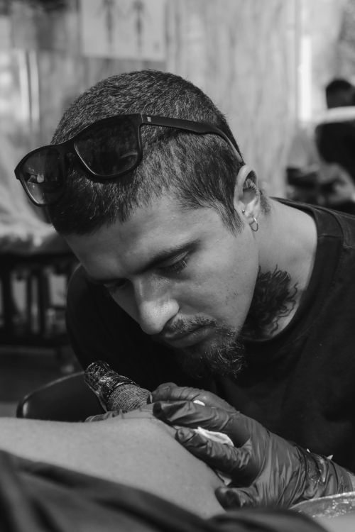 Free Black and white portrait of a tattoo artist focused on his work in Aydın, Türkiye. Stock Photo