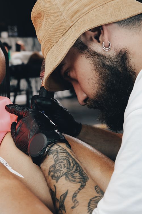 Free A tattoo artist deeply focused on creating a design in Aydın, Türkiye, depicting his craft. Stock Photo