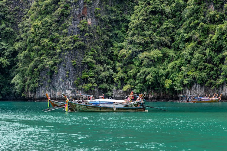 Boats Near Forest On Rocks On Sea Shore On Island In Thailand