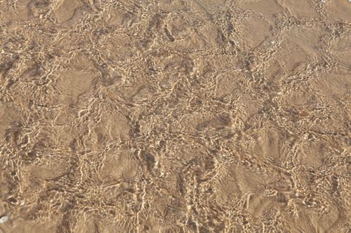 Free Rippling clear water over sandy beach in Cabourg, Normandy, France, showcasing natural beauty. Stock Photo