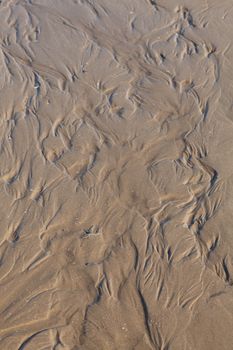 Close-up of intricate sand patterns at Cabourg Beach, Normandy, France.
