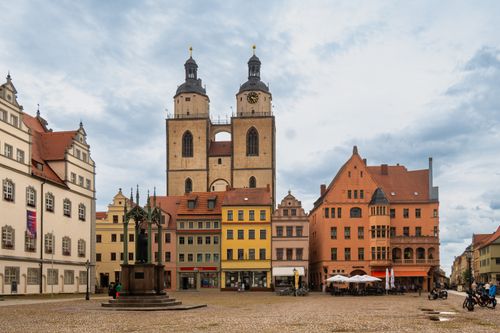 Free View of the Stadtkirche and colorful buildings in Wittenberg's Old Market Square, Germany. Stock Photo