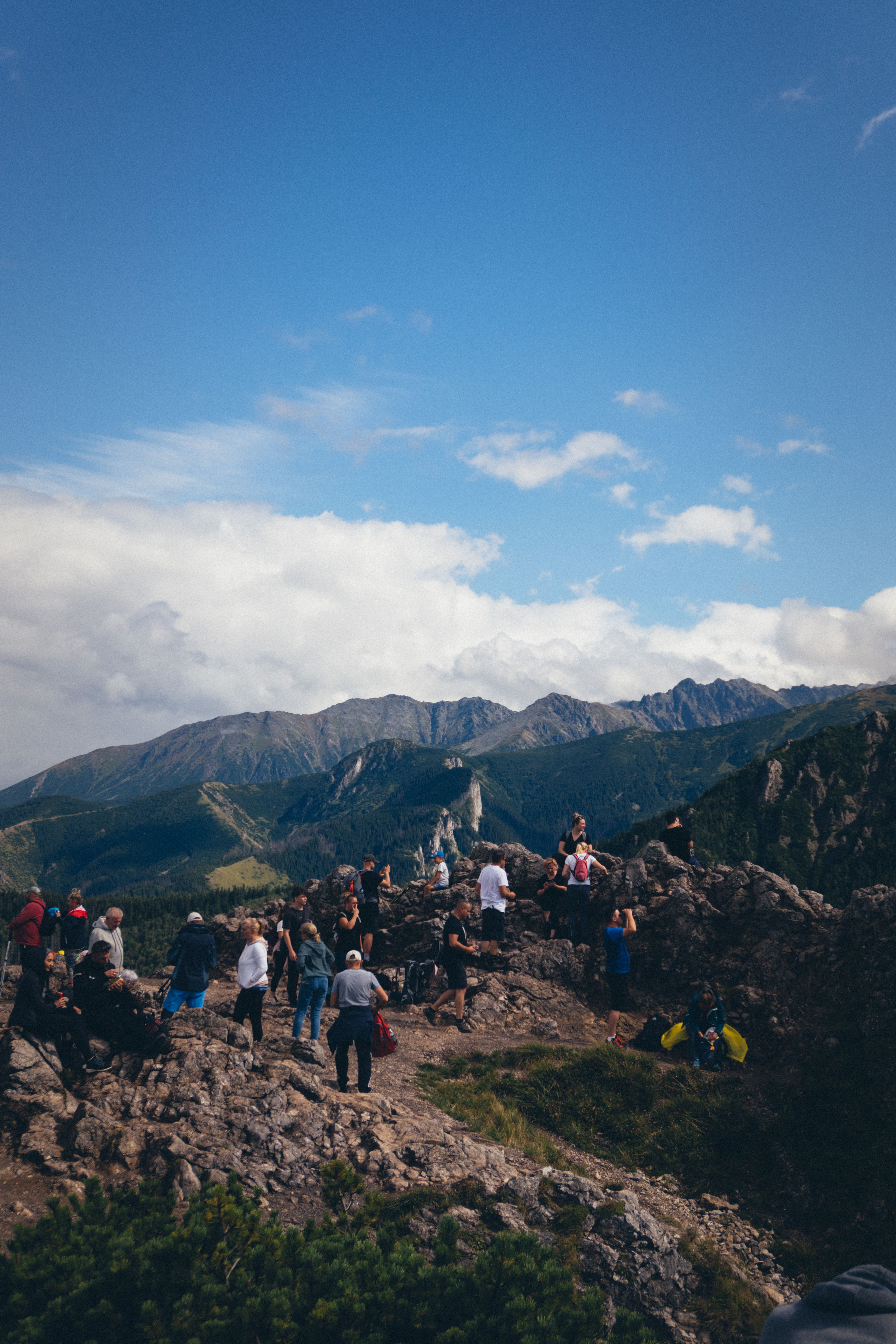 Group of Hikers Resting on Mountain Peak · Free Stock Photo