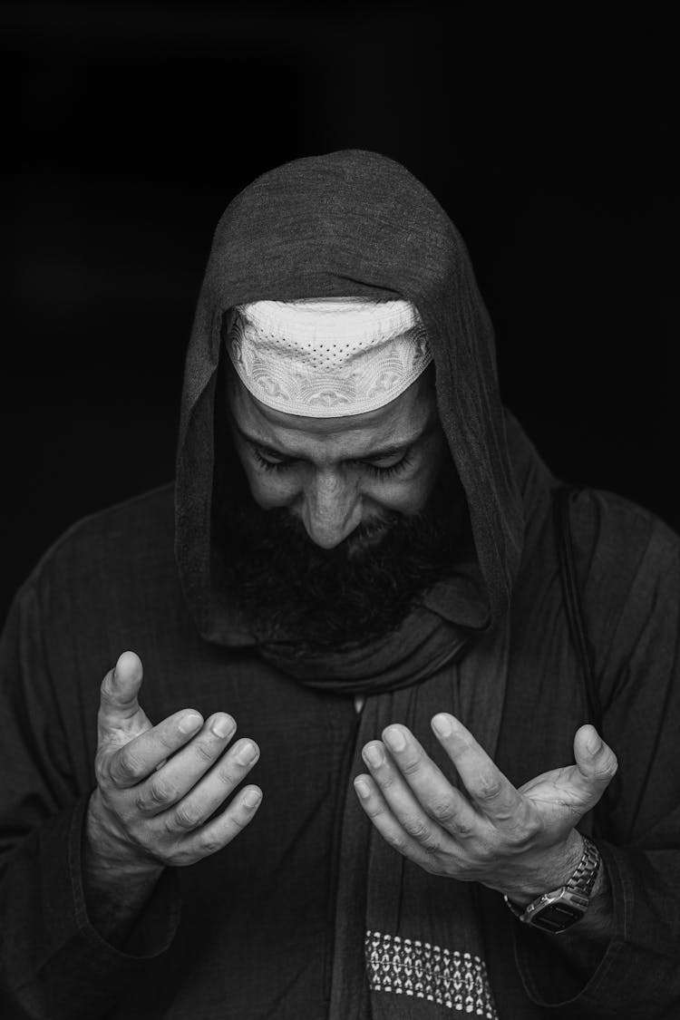 Man Praying In White Cap And Headscarf