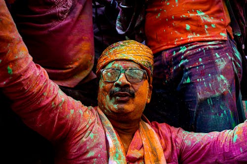 A Man Covered in Colorful Powder at a Holi Festival 