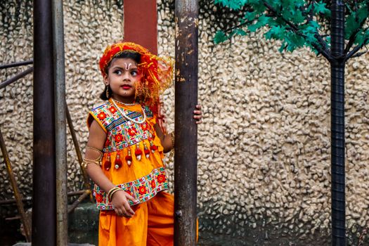 Young Indian girl in vibrant traditional attire during a celebration in Kolkata, India.