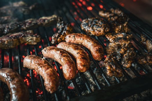 Close-up of sausages and meats roasting on a charcoal grill outdoors. Perfect for summer cookouts.