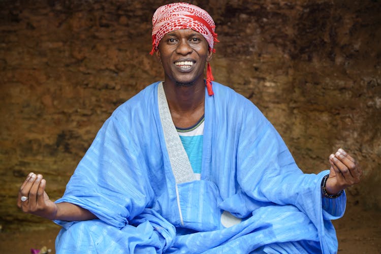 Smiling Man Sits In Meditation Pose