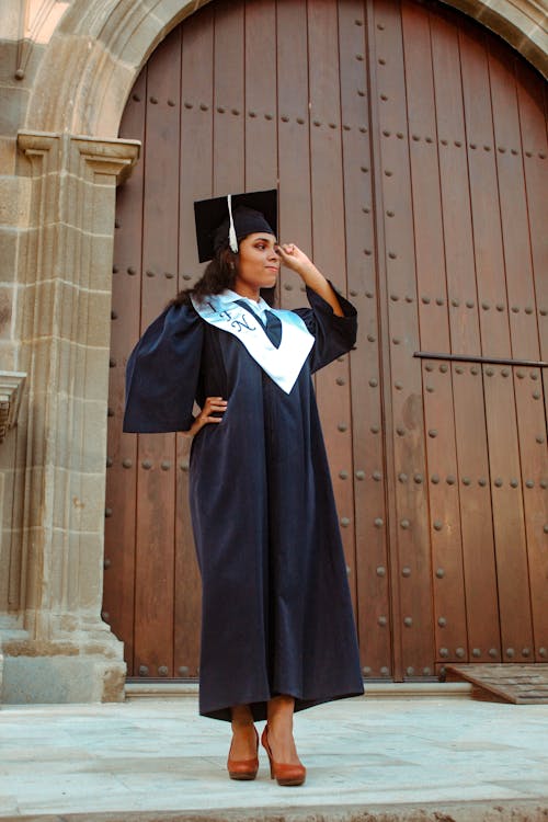 Young Woman in a Graduation Gown and a Mortarboard