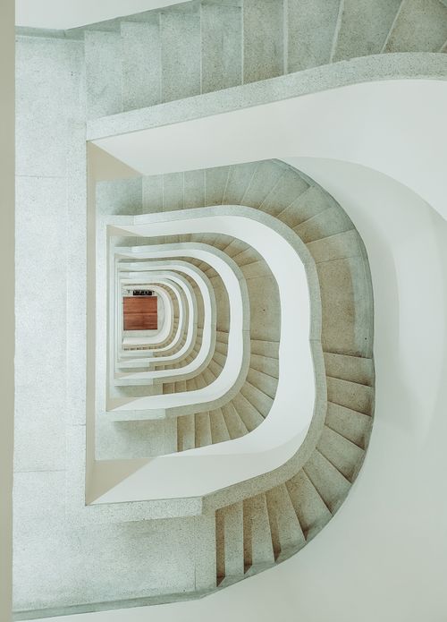 Free Minimalist vertical view of a spiral staircase in a modern architectural setting. Stock Photo