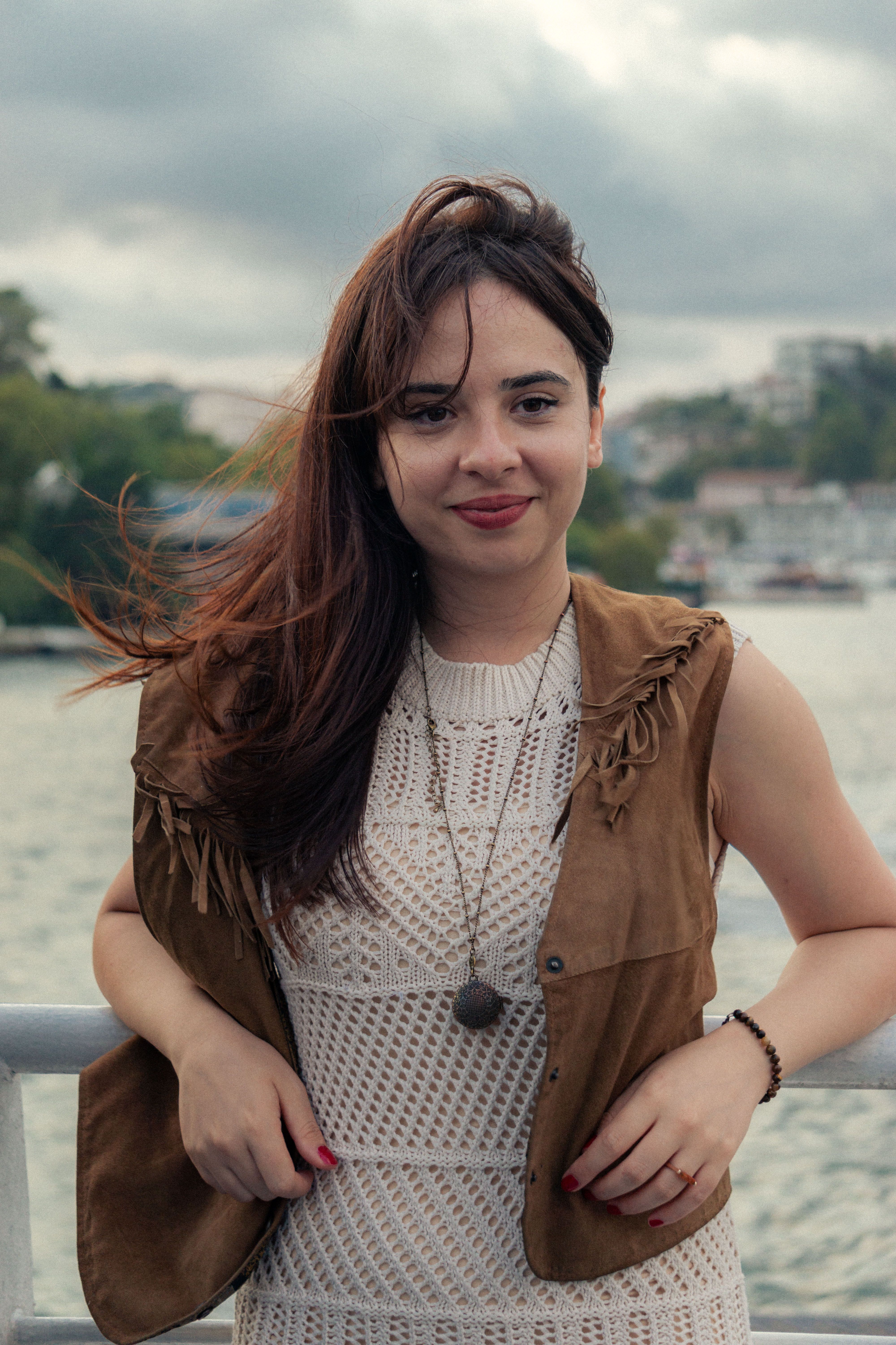 Portrait of a stylish woman smiling confidently outdoors, capturing a laid-back vibe.