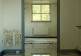 Standing water covering a room floor, reflecting the window