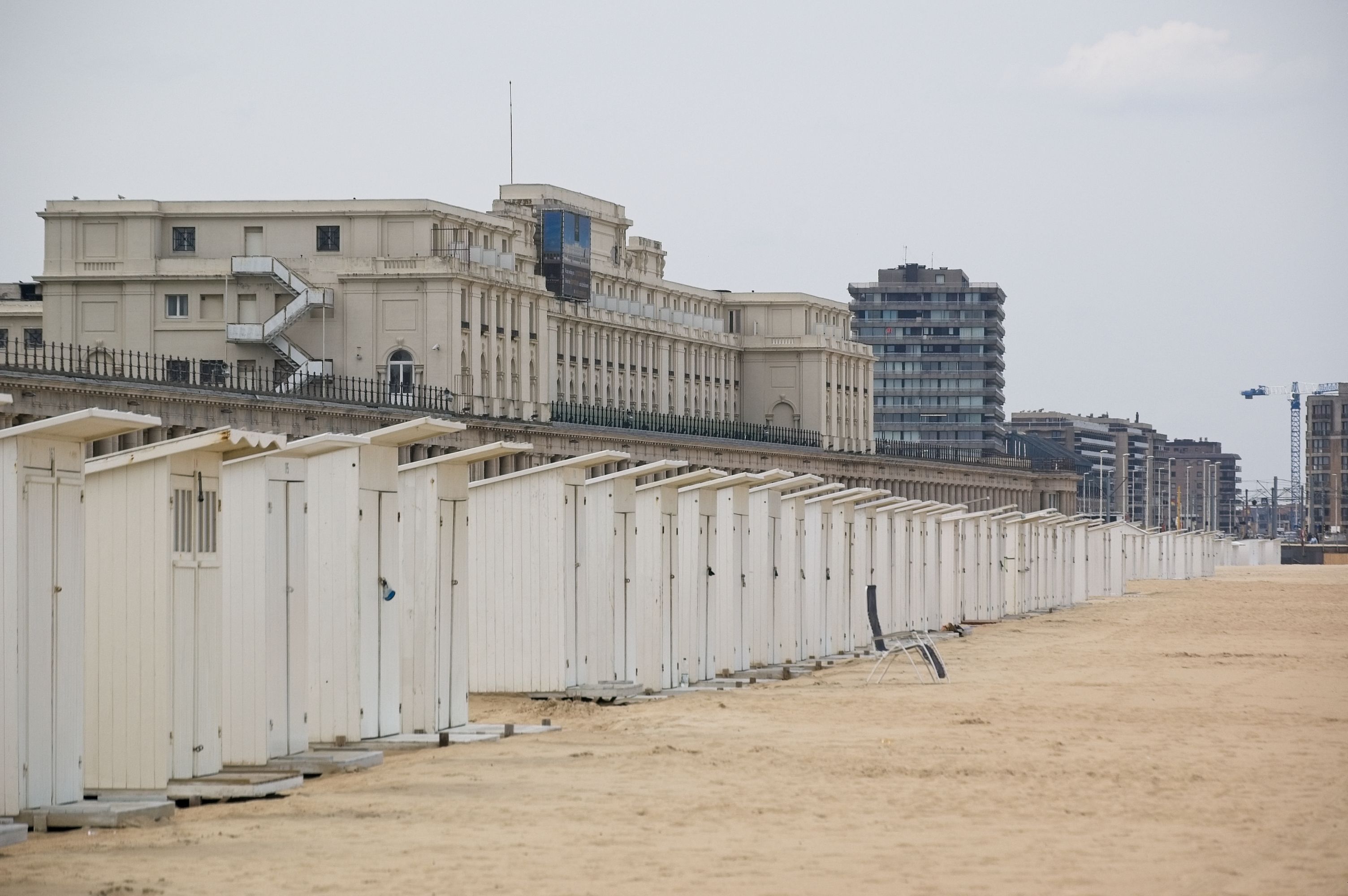 Lange rij witte strandcabines op het zand langs de Belgische kust
