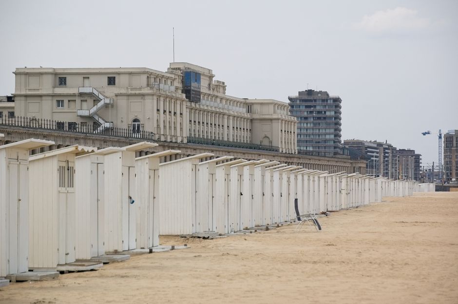 Lange rij witte strandcabines op het zand langs de Belgische kust