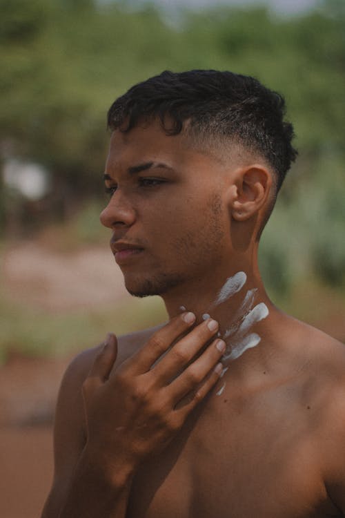 Young Man Putting White Paint on his Neck