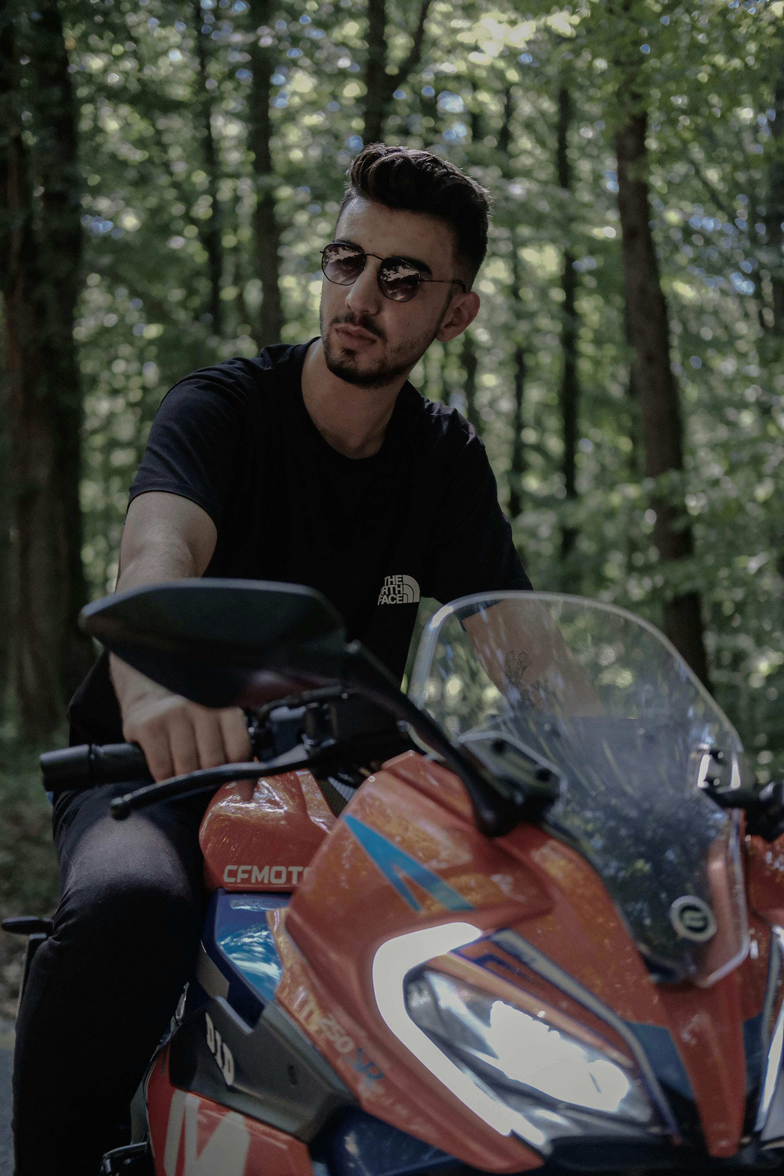 a man in sunglasses riding a motorcycle