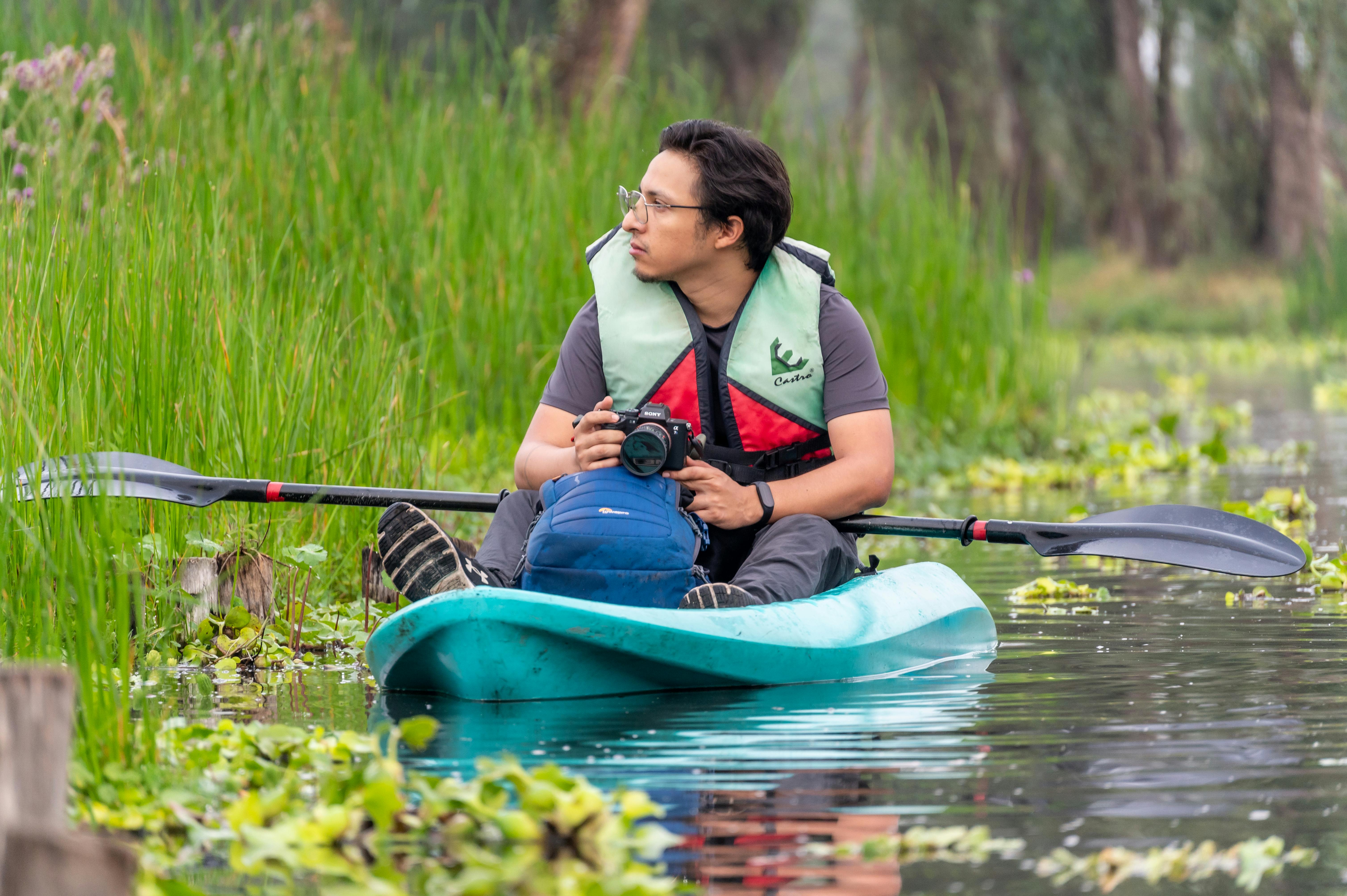A man kayaking in CDMX, México, capturing nature photography. Adventure in serene water landscape.