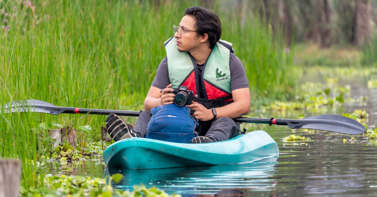 A man kayaking in CDMX, México, capturing nature photography. Adventure in serene water landscape.