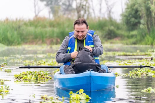A man kayaking through lush vegetation in CDMX, Mexico, enjoying a peaceful outdoor adventure.