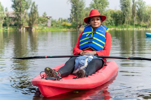 Free Woman enjoying a peaceful canoe ride on a picturesque lake in CDMX, Mexico. Stock Photo