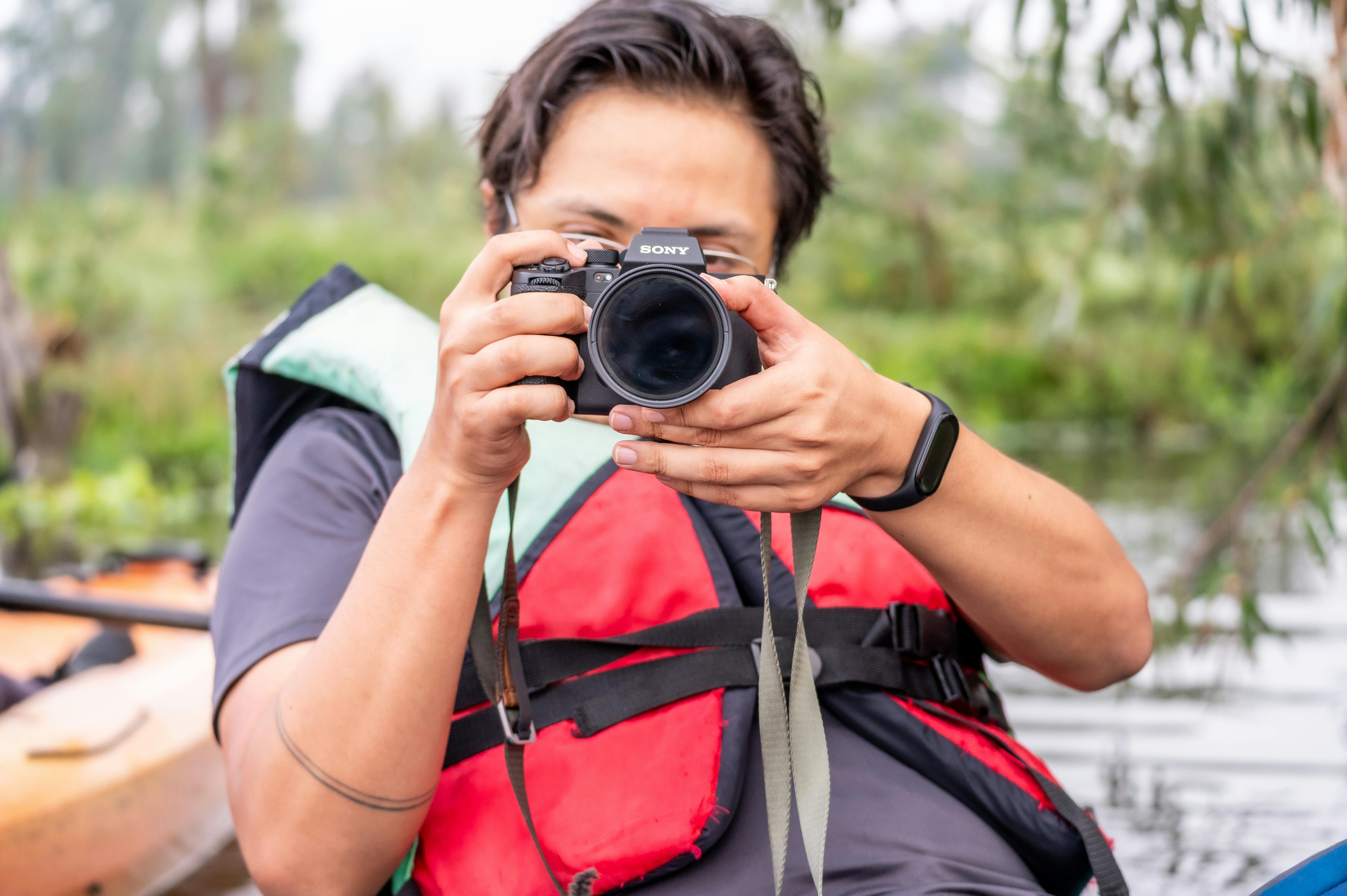 a man taking a photo with a camera in a canoe