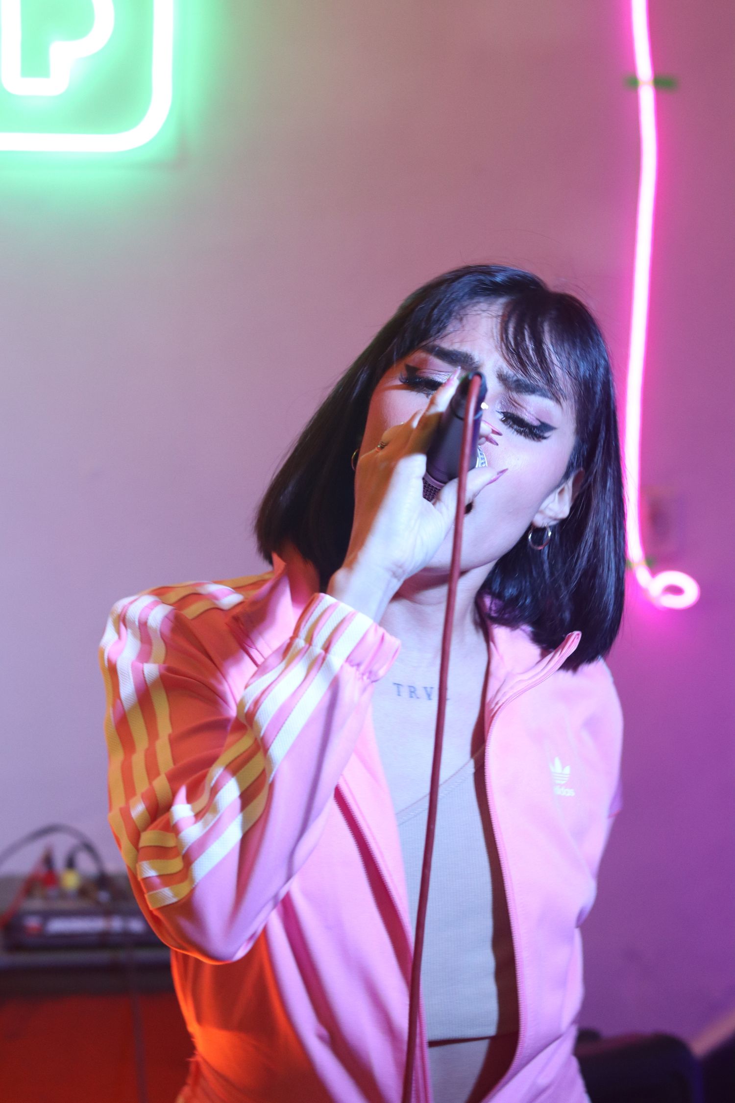 Pink jacket singer under dramatic stage glow