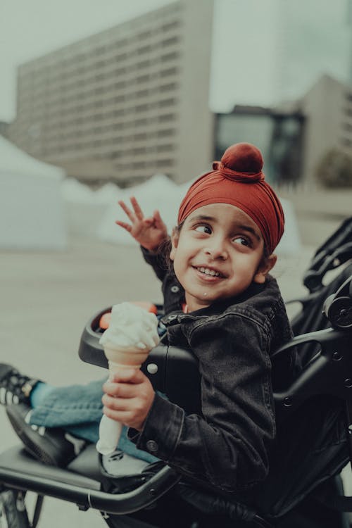 Smiling Boy Sitting with Ice Cream in Stroller