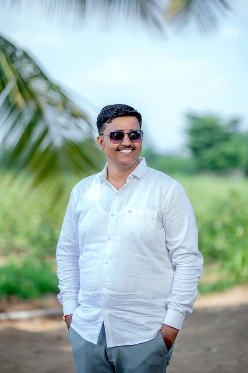 Free Cheerful man in white shirt and sunglasses smiling outdoors in Malegaon, India. Stock Photo