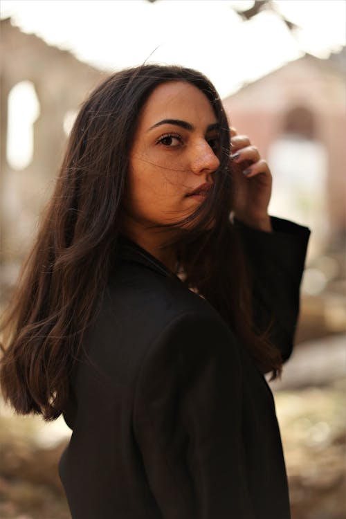 Young Brunette Standing Outside and Looking over Her Shoulder