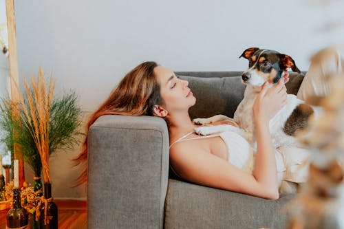 Woman Lying Down with Dog on Couch