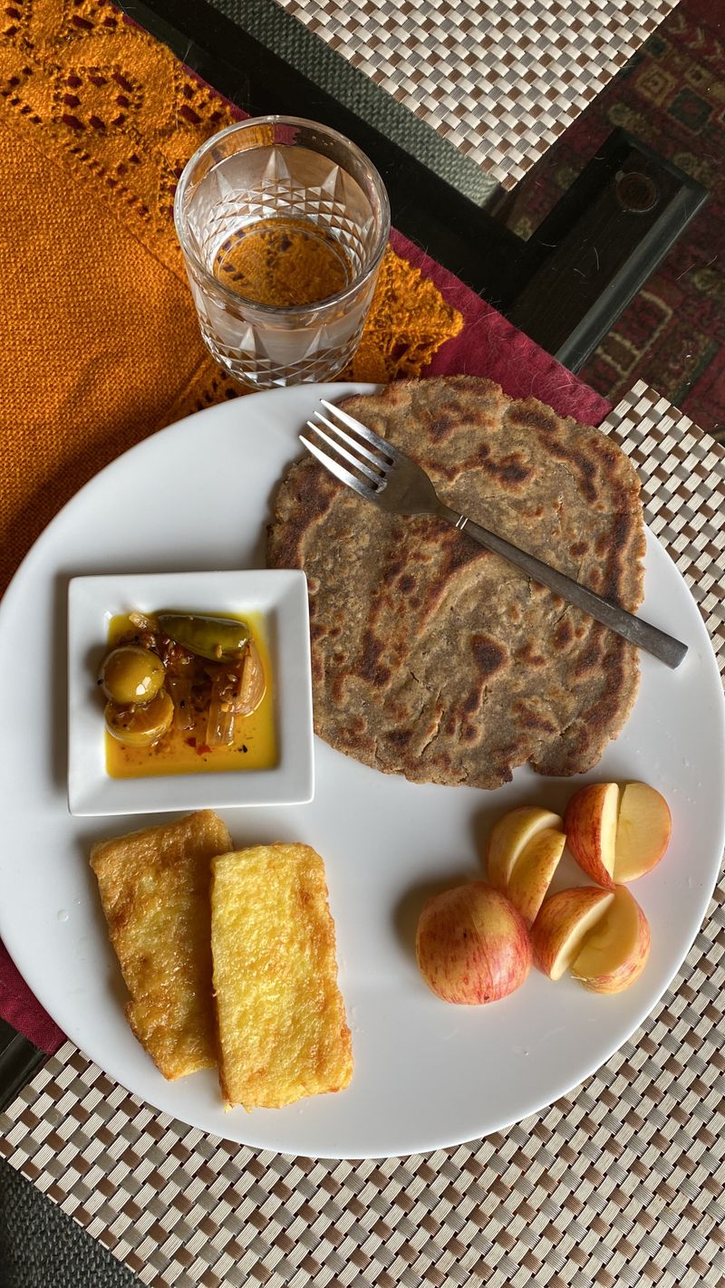 Healthy breakfast featuring paratha, fruit and a beverage