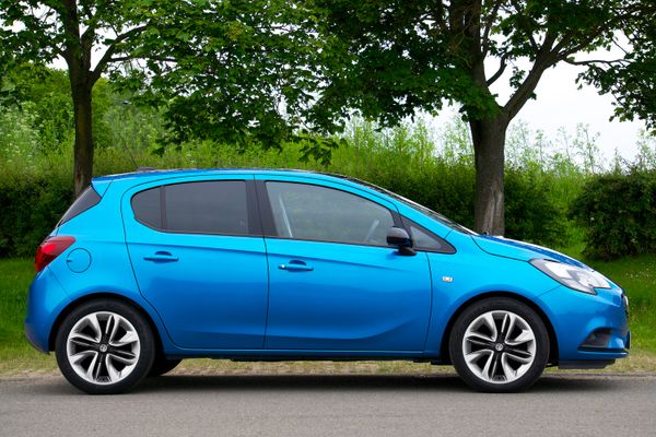 Blue compact hatchback parked beside trees, photo by Mike Bird on Pexels