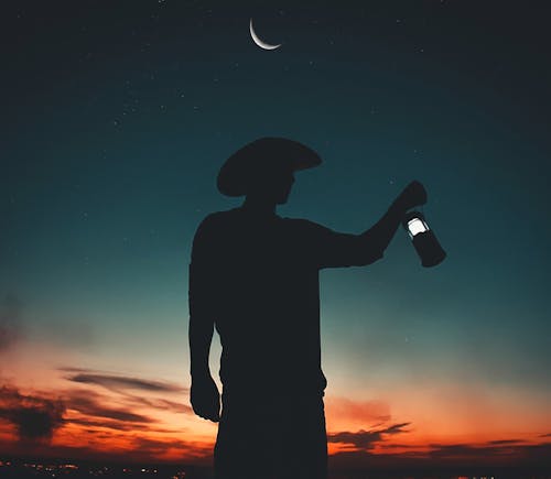 Silhouette Photo Of Man Holding Light Lantern 