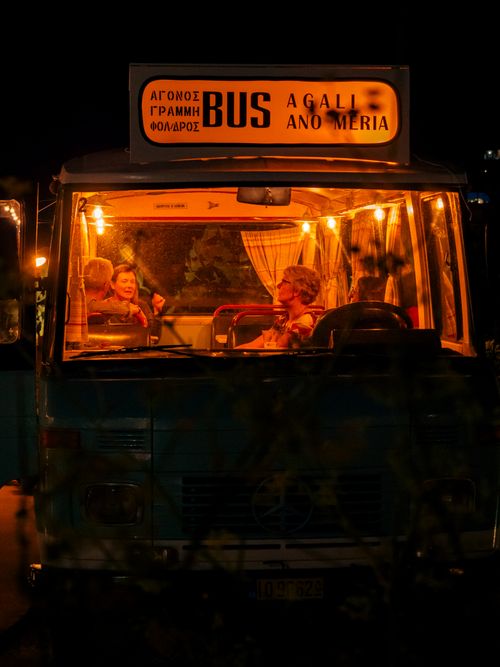Free Passengers enjoying a relaxed night ride on an illuminated bus. Stock Photo