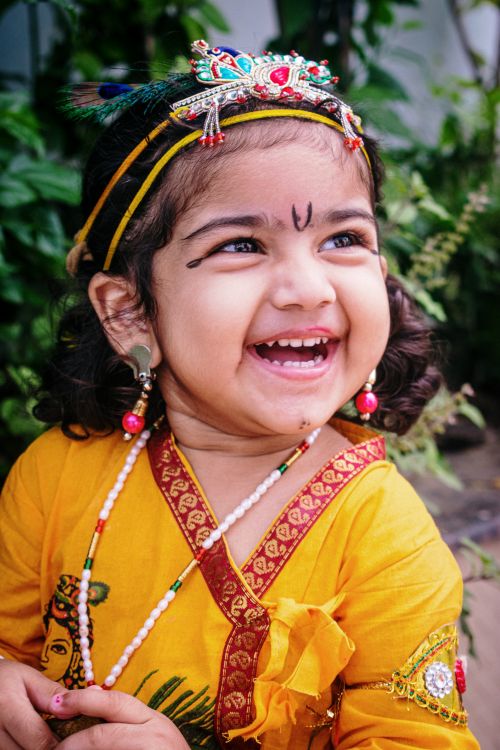 Free Adorable child in vibrant traditional attire with jewelry, radiating joy. Stock Photo