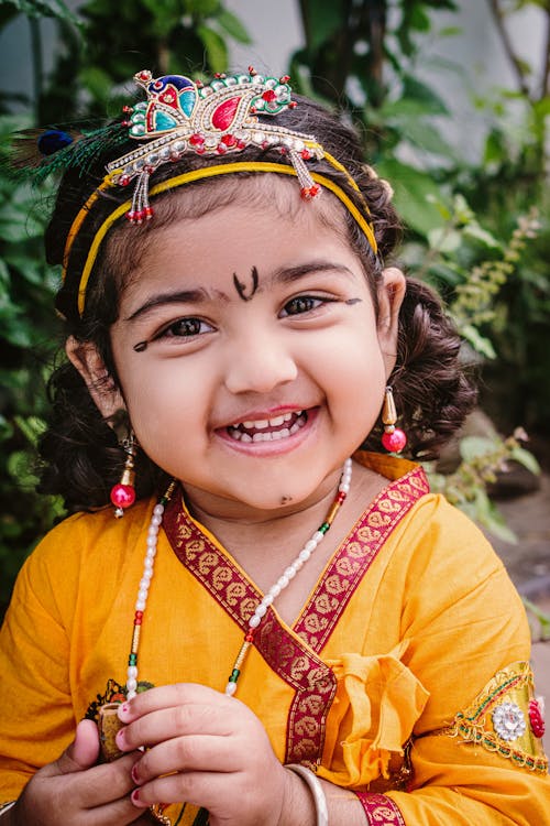 Smiling Girl in Traditional Clothing and Crown