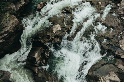 Free A dynamic view of a waterfall cascading over rocks, capturing the essence of nature's force. Stock Photo