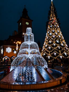 迷人的城镇广场上，美丽的圣诞树和喷泉营造出节日的夜间场景