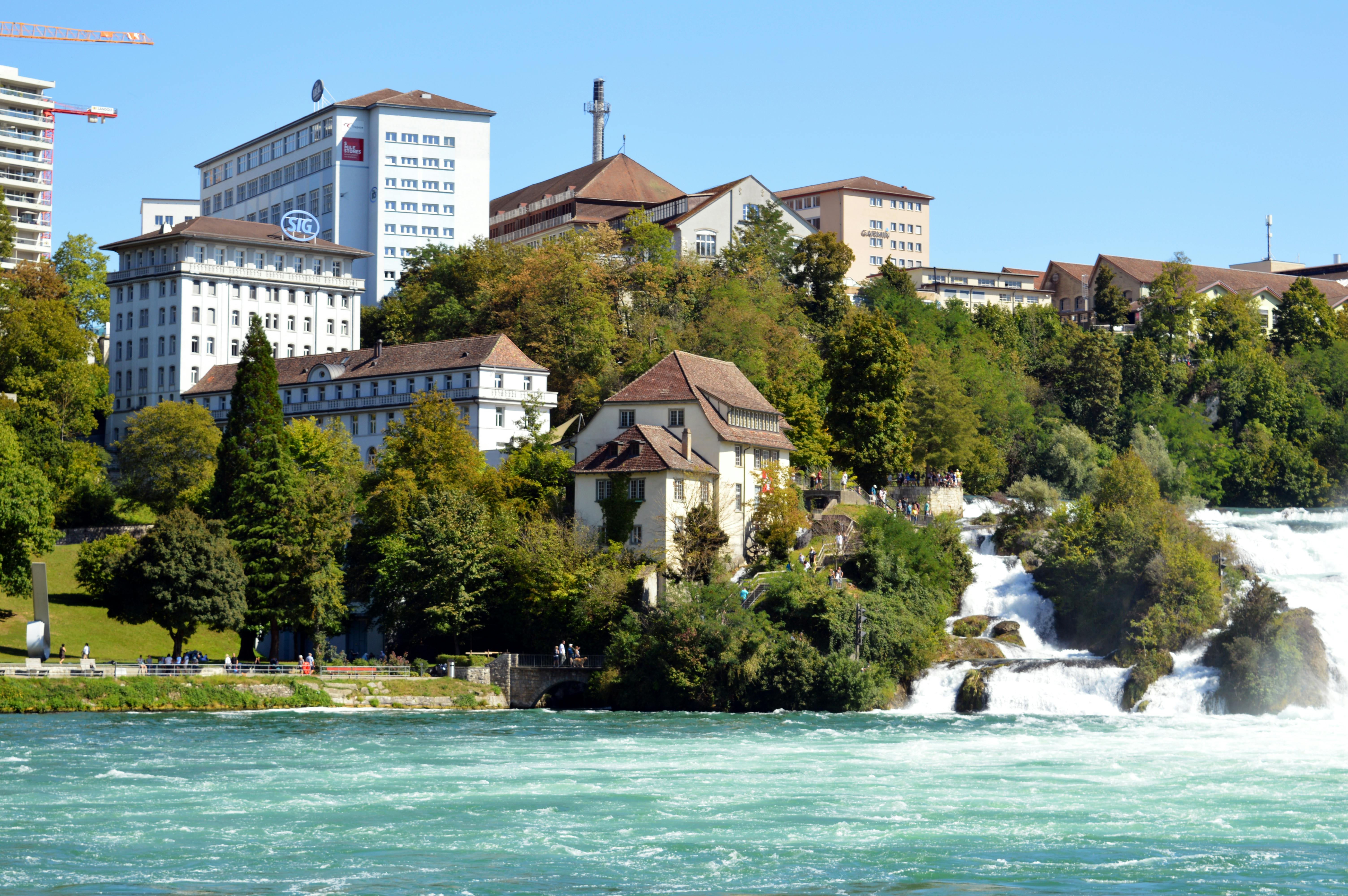Scenic view of Rhine Falls and surrounding architecture in Neuhausen am Rheinfall, Switzerland.